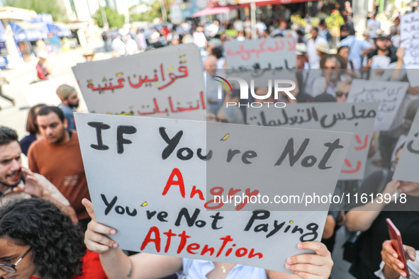 A demonstrator raises a placard that reads, ''If you are not angry, you are not paying attention,'' during a demonstration organized by the...