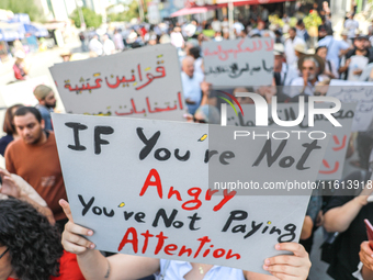 A demonstrator raises a placard that reads, ''If you are not angry, you are not paying attention,'' during a demonstration organized by the...