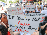 A demonstrator raises a placard that reads, ''If you are not angry, you are not paying attention,'' during a demonstration organized by the...