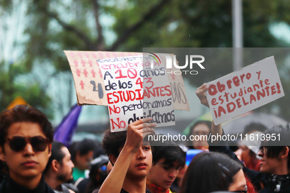 A person holds a placard while taking part in a protest in support of the parents of the rural student victims to demand justice during the...