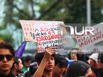 A person holds a placard while taking part in a protest in support of the parents of the rural student victims to demand justice during the...