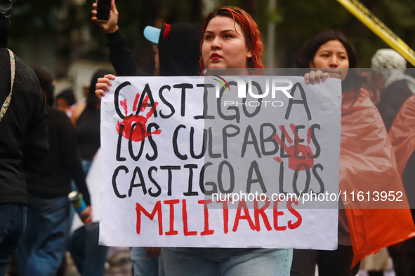 A person holds a placard while taking part in a protest in support of the parents of the rural student victims to demand justice during the...