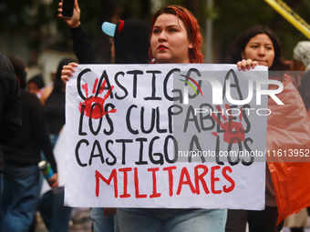 A person holds a placard while taking part in a protest in support of the parents of the rural student victims to demand justice during the...