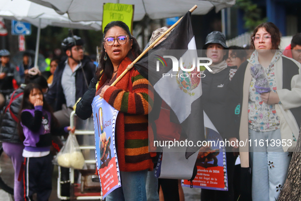 A person holds a placard while taking part in a protest in support of the parents of the rural student victims to demand justice during the...