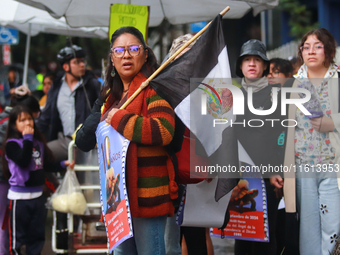 A person holds a placard while taking part in a protest in support of the parents of the rural student victims to demand justice during the...