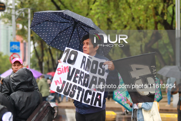 A person holds a placard while taking part in a protest in support of the parents of the rural student victims to demand justice during the...