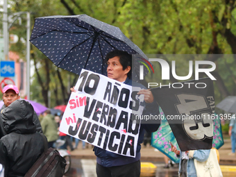 A person holds a placard while taking part in a protest in support of the parents of the rural student victims to demand justice during the...