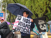 A person holds a placard while taking part in a protest in support of the parents of the rural student victims to demand justice during the...