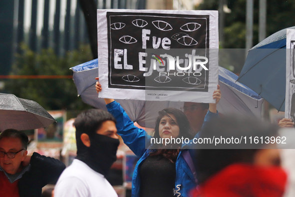 A person holds a white placard during a protest in support of the parents of the rural student victims to demand justice on the 10th anniver...