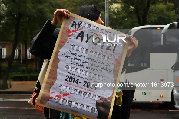 A person holds a white placard during a protest in support of the parents of the rural student victims to demand justice on the 10th anniver...