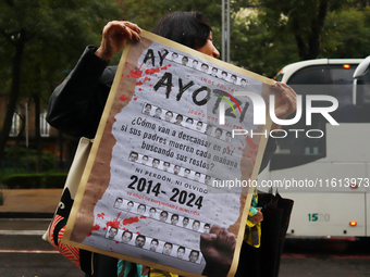 A person holds a white placard during a protest in support of the parents of the rural student victims to demand justice on the 10th anniver...