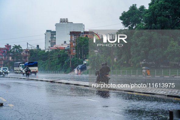 People's daily lives are affected by the heavy rainfall in Kathmandu, Nepal, on September 27, 2024. People wear raincoats and travel to thei...