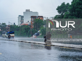 People's daily lives are affected by the heavy rainfall in Kathmandu, Nepal, on September 27, 2024. People wear raincoats and travel to thei...