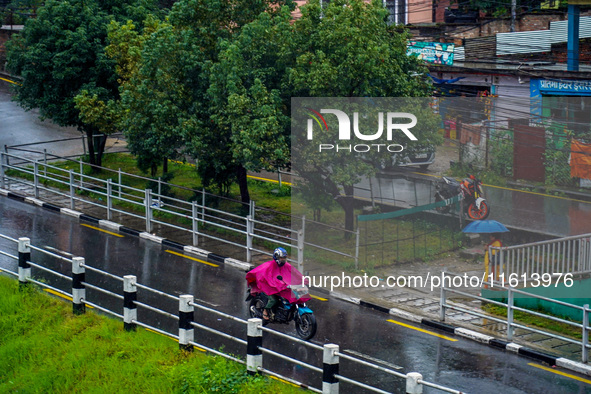 People's daily lives are affected by the heavy rainfall in Kathmandu, Nepal, on September 27, 2024. People wear raincoats and travel to thei...