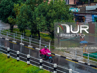 People's daily lives are affected by the heavy rainfall in Kathmandu, Nepal, on September 27, 2024. People wear raincoats and travel to thei...