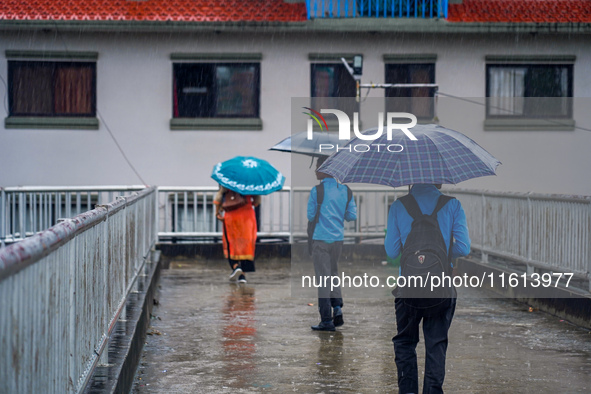 People's daily lives are affected by the heavy rainfall in Kathmandu, Nepal, on September 27, 2024. People use umbrellas and travel to their...