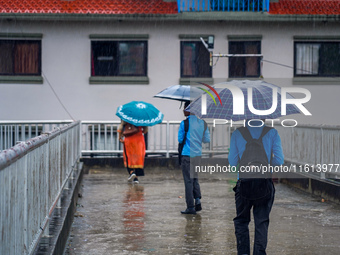 People's daily lives are affected by the heavy rainfall in Kathmandu, Nepal, on September 27, 2024. People use umbrellas and travel to their...