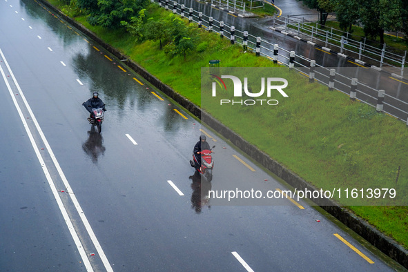 People's daily lives are affected by the heavy rainfall in Kathmandu, Nepal, on September 27, 2024. People wear raincoats and travel to thei...