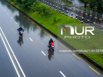 People's daily lives are affected by the heavy rainfall in Kathmandu, Nepal, on September 27, 2024. People wear raincoats and travel to thei...