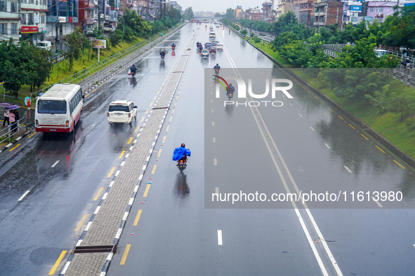 People's daily lives are affected by the heavy rainfall in Kathmandu, Nepal, on September 27, 2024. People wear raincoats and travel to thei...