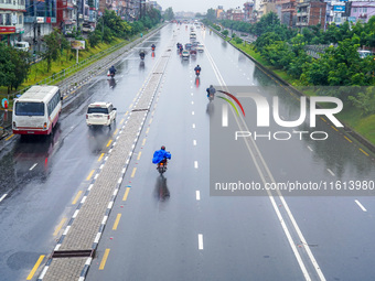 People's daily lives are affected by the heavy rainfall in Kathmandu, Nepal, on September 27, 2024. People wear raincoats and travel to thei...