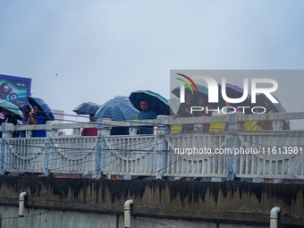 People's daily lives are affected by the heavy rainfall in Kathmandu, Nepal, on September 27, 2024. People use umbrellas and travel to their...