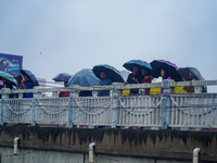 People's daily lives are affected by the heavy rainfall in Kathmandu, Nepal, on September 27, 2024. People use umbrellas and travel to their...