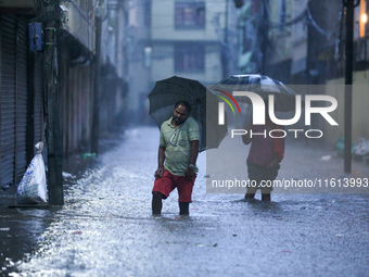 People wade through the flood water in Kathmandu, Nepal, on September 27, 2024. The Himalayan nation witnesses downpour after the activation...