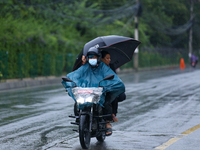 Drivers wear raincoats and carry umbrellas after incessant rainfall in Kathmandu, Nepal, on September 27, 2024, following a red alert issued...