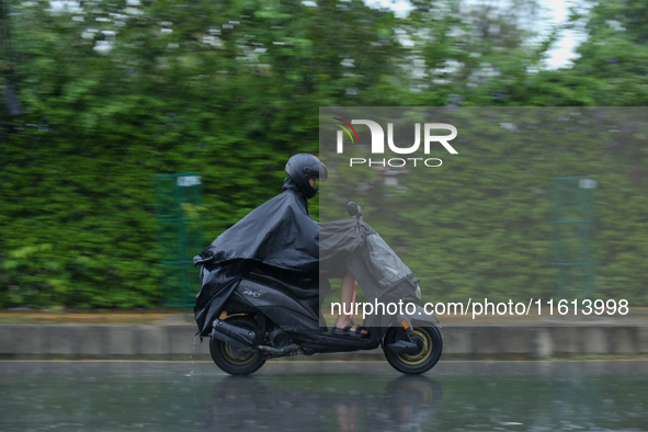 A motorcyclist wearing a raincoat drives along the roads of Kathmandu, Nepal, on September 27, 2024, following incessant rainfall and the is...