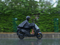 A motorcyclist wearing a raincoat drives along the roads of Kathmandu, Nepal, on September 27, 2024, following incessant rainfall and the is...