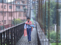 A Nepali student crosses a suspension bridge following incessant rainfall after the red alert issued by Nepal's weather department on Septem...