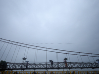 People cross a suspension bridge following incessant rainfall after the red alert issued by Nepal's weather department on September 27, 2024...