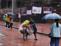 A vendor pushes his load-laden bicycle through Patan Durbar Square, a UNESCO World Heritage Site, in Patan, Nepal, on September 27, 2024, af...