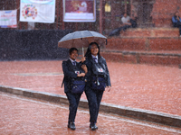 Nepali students wear umbrellas as they walk around Patan Durbar Square, a UNESCO World Heritage site in Lalitpur, Nepal, on September 27, 20...