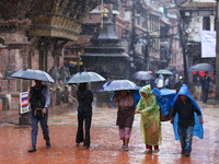 People with umbrellas walk around Patan Durbar Square, a UNESCO World Heritage Site in Lalitpur, Nepal, on September 27, 2024, after incessa...