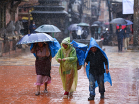 People with umbrellas walk around Patan Durbar Square, a UNESCO World Heritage Site in Lalitpur, Nepal, on September 27, 2024, after incessa...