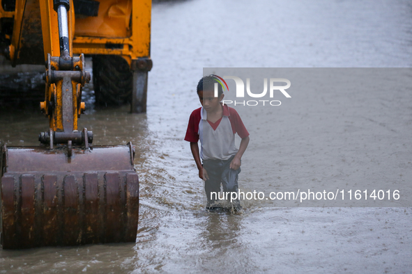 A Nepali boy wades through the flood water in Kathmandu, Nepal, on September 27, 2024. The Himalayan nation witnesses downpour after the act...