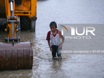 A Nepali boy wades through the flood water in Kathmandu, Nepal, on September 27, 2024. The Himalayan nation witnesses downpour after the act...