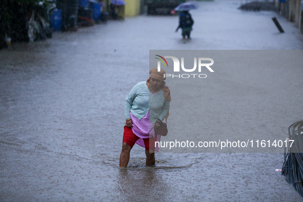 A Nepali woman wades through the floodwater in Kathmandu, Nepal, on September 27, 2024. The Himalayan nation witnesses a downpour after the...