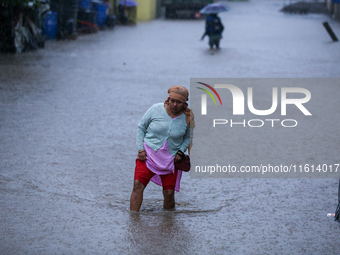 A Nepali woman wades through the floodwater in Kathmandu, Nepal, on September 27, 2024. The Himalayan nation witnesses a downpour after the...