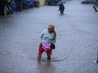 A Nepali woman wades through the floodwater in Kathmandu, Nepal, on September 27, 2024. The Himalayan nation witnesses a downpour after the...