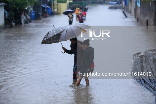 A Nepali woman wades through the floodwater in Kathmandu, Nepal, on September 27, 2024. The Himalayan nation witnesses a downpour after the...