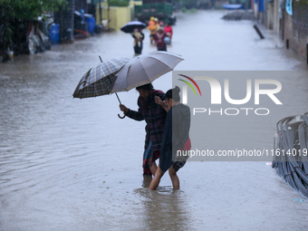 A Nepali woman wades through the floodwater in Kathmandu, Nepal, on September 27, 2024. The Himalayan nation witnesses a downpour after the...