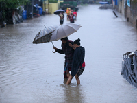 A Nepali woman wades through the floodwater in Kathmandu, Nepal, on September 27, 2024. The Himalayan nation witnesses a downpour after the...