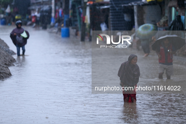 A Nepali woman wades through the floodwater in Kathmandu, Nepal, on September 27, 2024. The Himalayan nation witnesses a downpour after the...