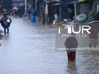 A Nepali woman wades through the floodwater in Kathmandu, Nepal, on September 27, 2024. The Himalayan nation witnesses a downpour after the...