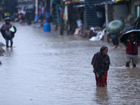 A Nepali woman wades through the floodwater in Kathmandu, Nepal, on September 27, 2024. The Himalayan nation witnesses a downpour after the...