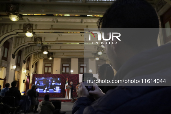 A reporter takes pictures of Andres Manuel Lopez Obrador, president of Mexico, during his penultimate press conference at the National Palac...