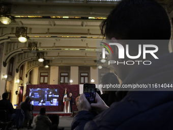 A reporter takes pictures of Andres Manuel Lopez Obrador, president of Mexico, during his penultimate press conference at the National Palac...